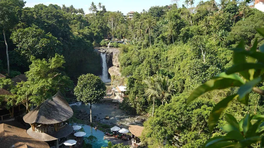 Wide curtain of Tegenungan Waterfall dropping into a jungle pool near Ubud Bali, viewed from the stone stairway